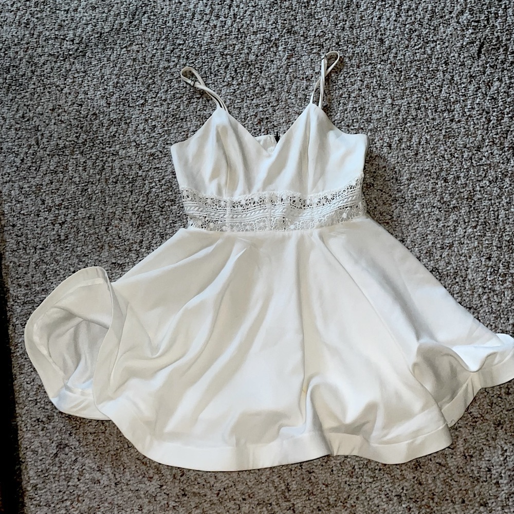 white sundress with a strip of lace through the center